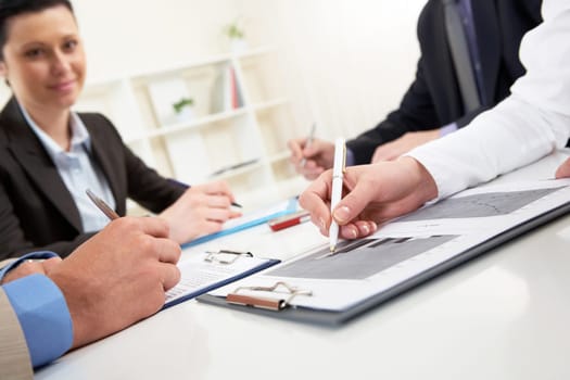Close-up of business person hand over document in working environment