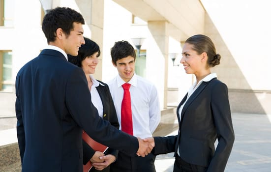 Photo of successful associates handshaking after striking deal outdoors at meeting