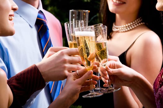 Image of human hands holding the glasses of champagne making a toast