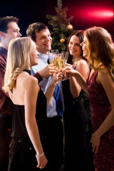 Group of five friends clinking  glasses with each other at christmas