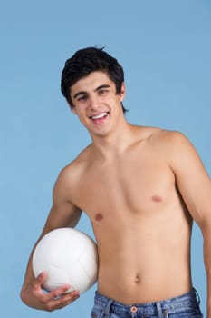 Portrait of handsome lad holding white ball over blue background