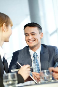 A mature man talking to his female colleague