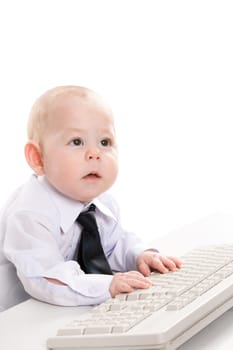 Portrait of serious baby boy typing on keyboard and looking aside