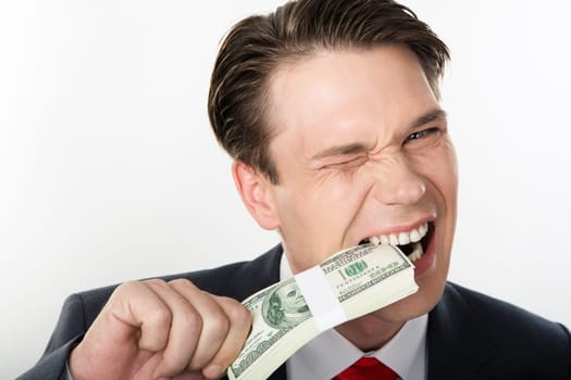 Close-up of strange businessman biting dollars by his teeth