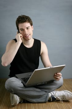 casual student talking mobile phone laptop sit over gray grunge background