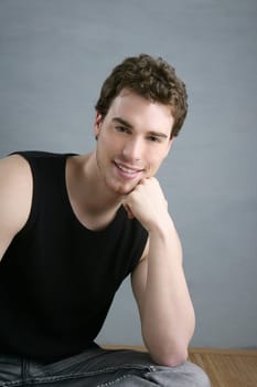 casual young man portrait sit over gray grunge background