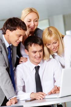 Four business people working with laptop in office