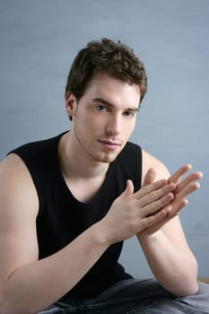 casual young man portrait sit over gray grunge background