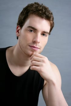 young man portrait posing looking camera over gray background