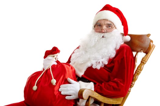 Santa sitting in the armchair and holding a sack isolated on white