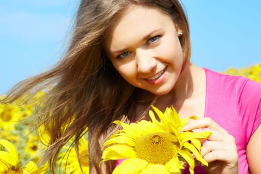 Photo of pretty girl with sunflower looking at camera on sunny day