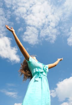 Image of happy female standing with raised arms on summer day