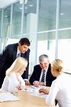 Business team of four people sitting and working together