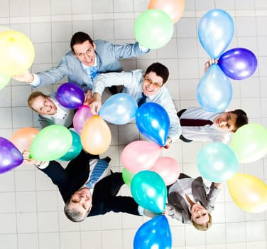 Above view of several successful partners with colorful balloons looking at camera