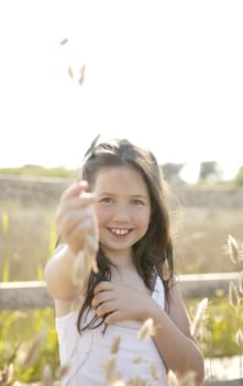 Girl at the park playing with flower spike in summertime
