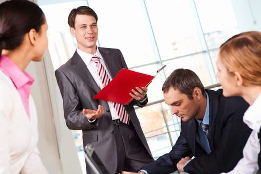 Image of businessman presenting new project or plan to his colleagues