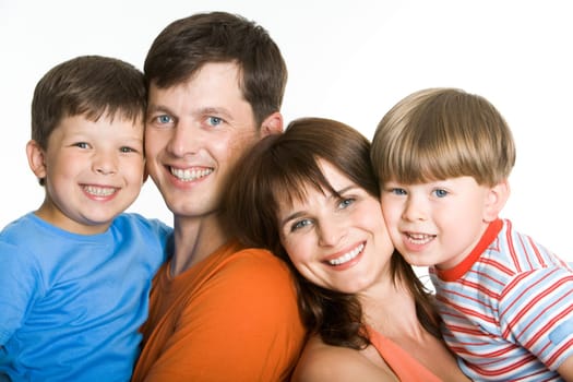 Portrait of joyful parents holding their sons and looking at camera