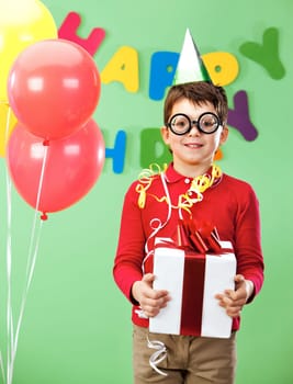 Portrait of happy lad in funny eyeglasses on birthday party with giftbox