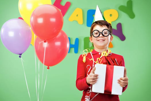 Portrait of happy lad in funny eyeglasses on birthday party with giftbox