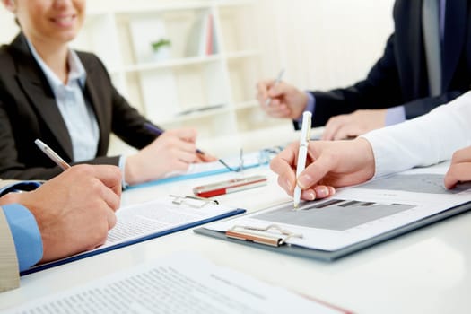Close-up of business person hand over document in working environment