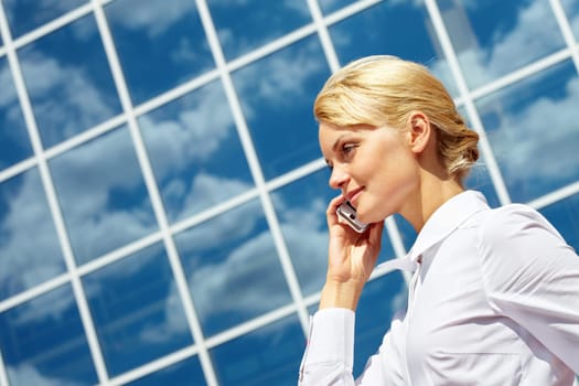 Portrait of pretty business leader talking by mobile phone with smile
