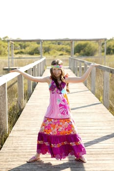 Beautiful teen girl with pink purple flower dress in the park
