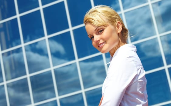 Image of pretty businesswoman looking aside on background of modern building outdoors