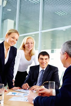 Three businesspeople looking at their boss