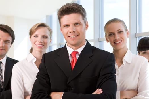 Several business partners looking at camera with successful man in front