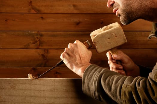 gouge wood chisel carpenter tool hammer in hand working wooden background