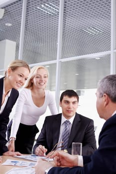 Three businesspeople looking at their boss