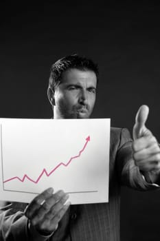 Businessman with good sales reports graph, studio shot black background