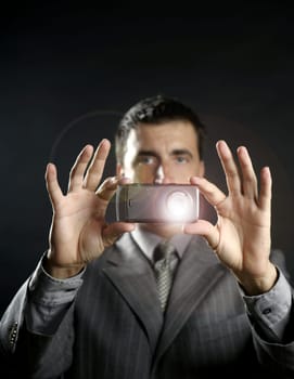 Businessman taking photos, mobile camera, black background