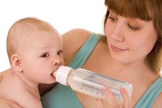 Careful mother holds bottle of milk while her adorable baby drinking it
