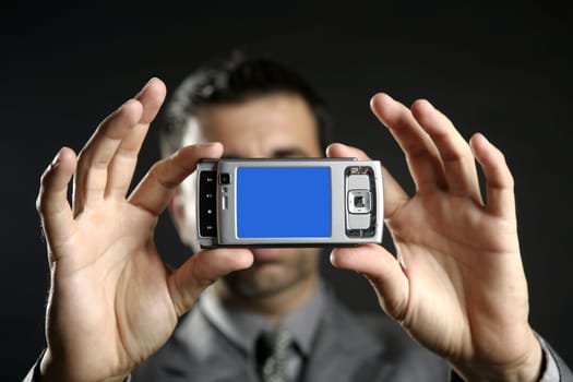 Businessman taking photos, mobile camera, black background