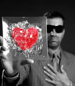 Broken red glass heart businessman metaphor, black background studio shot