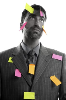 Businessman full of memo stock message notes over white studio background