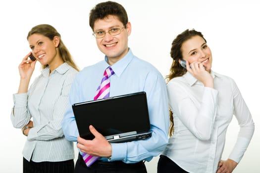 Photo of happy businessman with laptop standing between two smiling ladies speaking on cellphones