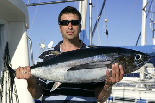Big game fisherman with saltwater tuna catch in his hands