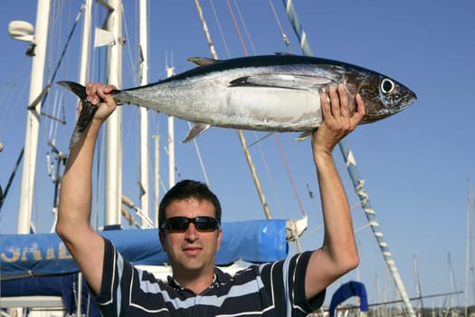Big game fisherman with saltwater tuna catch in his hands