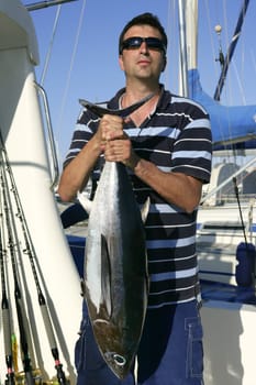 Big game fisherman with saltwater tuna catch in his hands