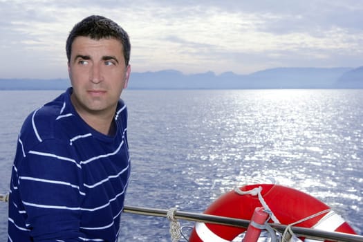 Male sailorman on blue sea boat looking ocean horizon