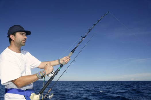 Angler fisherman trolling rod and reel fighting saltwater fish