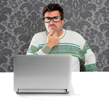 Nerd pensive man with glasses and silly expression in front a laptop computer looking for solution