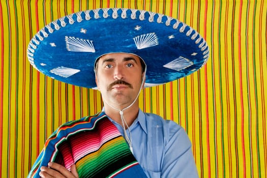 Mexican mustache man portrait with sombrero holding serape in shoulder