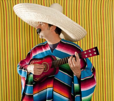 Mexican man serape poncho sombrero playing guitar typical Mexico