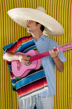 Mexican man serape poncho sombrero playing guitar typical Mexico