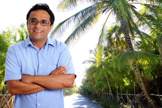 Latin man tourist portrait in tropical caribbean road with palm trees