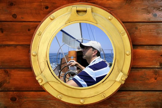 Sailor on sailboat summer holidays view from boat round window