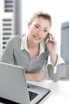 Businesswoman with laptop happy talking with mobile phone